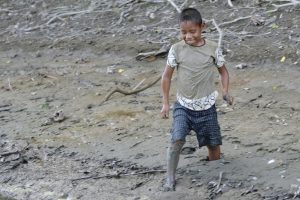 Boy wades through mud.
