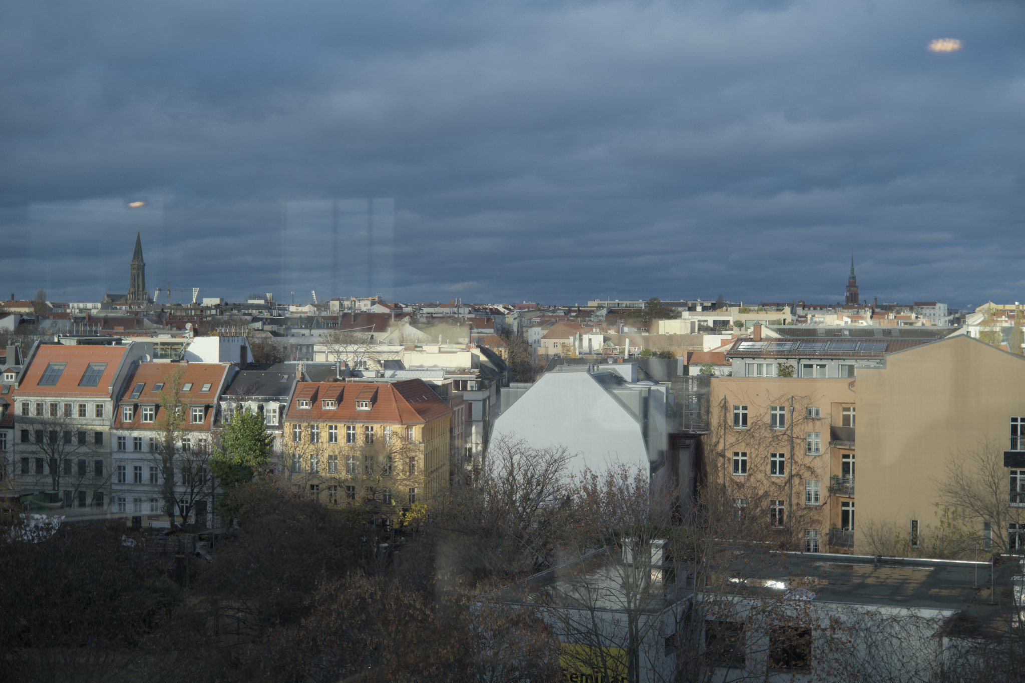 Afternoon sunlight strikes skyline beneath heavy clouds.