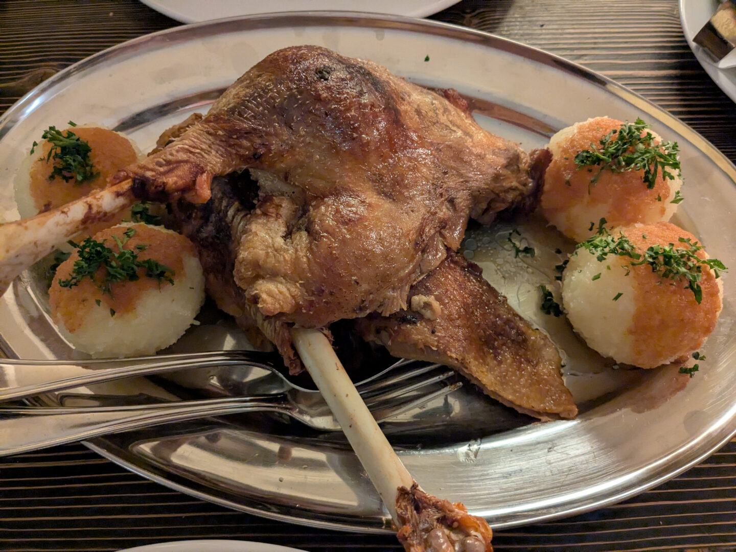 Half a roast goose, with potato dumpling balls on the side.